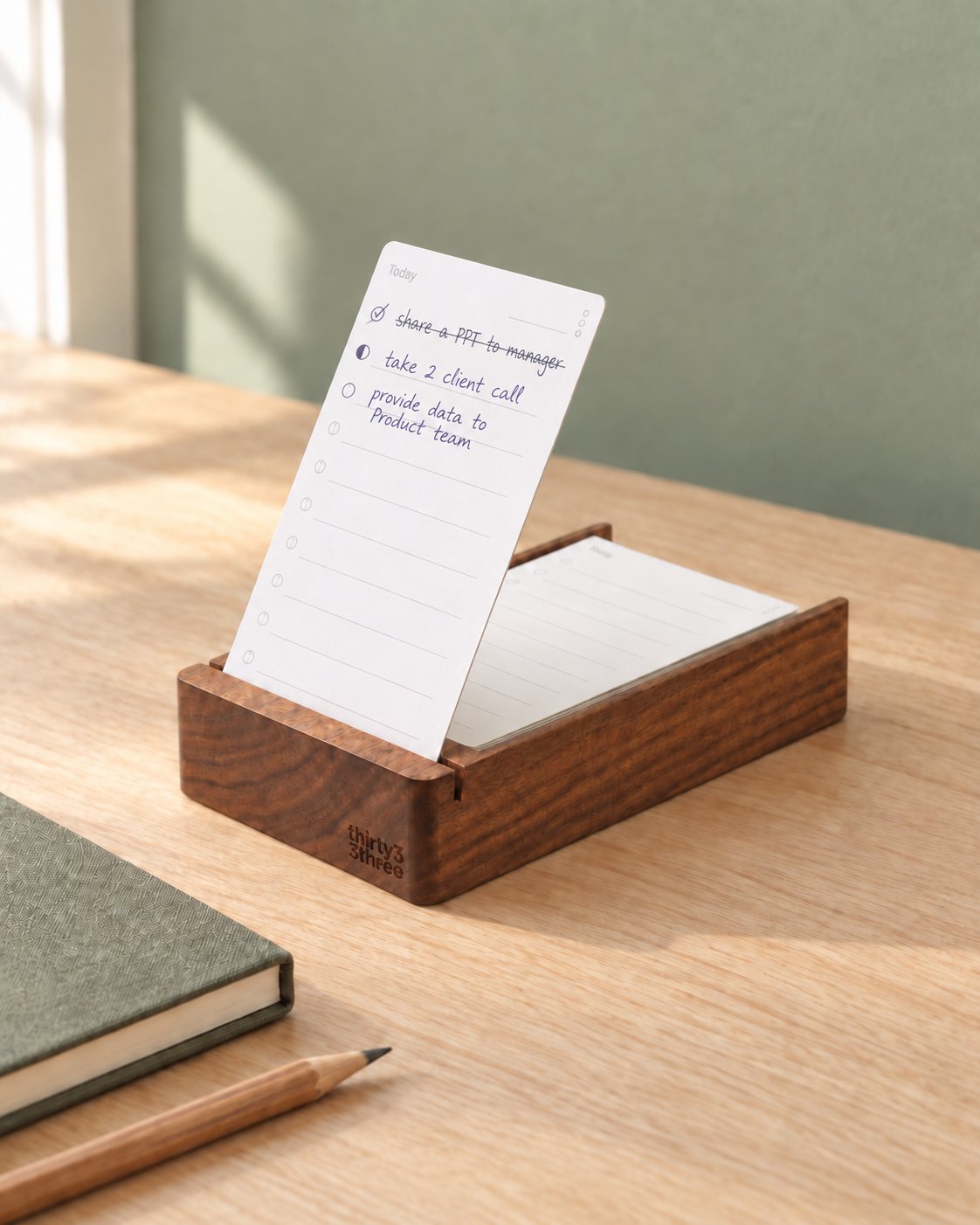 Lifestyle concept: the branded list holder on a sunlit desk beside a notebook and pencil